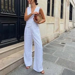 Completo chic gilet in lino bianco e pantaloni larghi su modella da strada