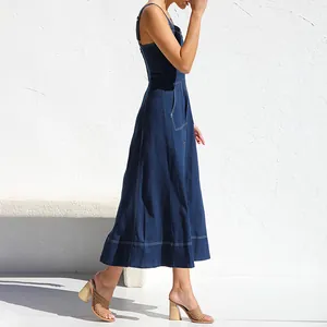 Vista laterale dettagliata di un abito midi in denim blu scuro con spalline e tasche