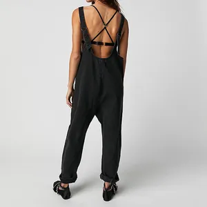 Back view of black denim overalls with adjustable crisscross straps and loose fit