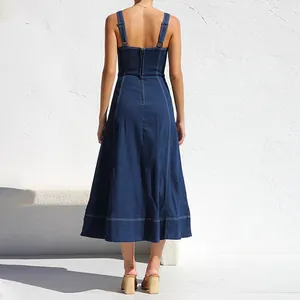 Vista posteriore dettagliata di un abito midi lungo in denim blu scuro con spalline e zip