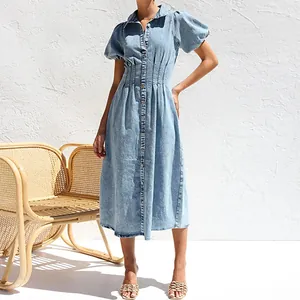 Full view of light blue denim midi dress with puff sleeves and button-down front