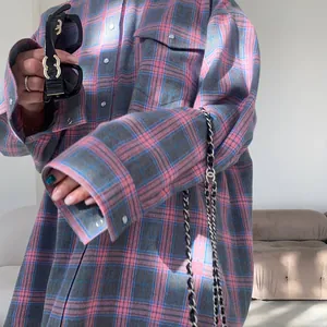 Primo piano di una camicia a maniche lunghe a scacchi rosa e grigi con tasche e polsini