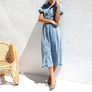 Close-up of casual light blue denim puff sleeve midi shirt dress in outdoor light