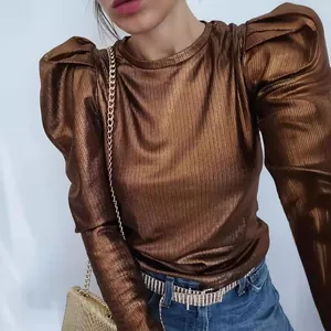 Detail of a metallic bronze long-sleeve T-shirt featuring stylish puff shoulders.