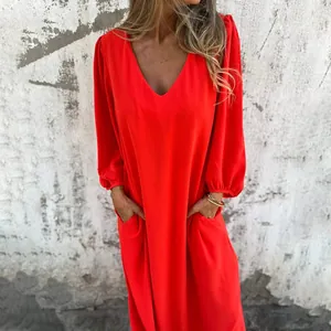 Close-up detail of casual red V-neck dress featuring loose lantern sleeves and side pockets