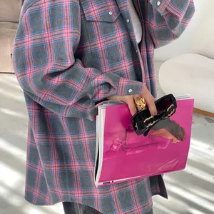 Dettaglio di una camicia di flanella a scacchi rosa e grigio con tasca e bottoni argentati