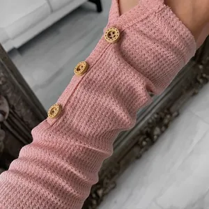 Detailed close-up of pink waffle knit sleeve with three decorative wooden buttons