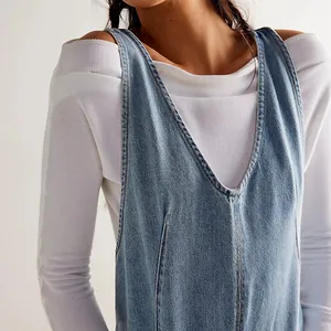 Close-up of washed blue denim overalls featuring V-neckline and white ribbed top.
