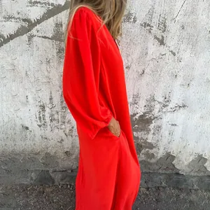 Side view of elegant red loose V-neck maxi dress featuring lantern sleeves and side pockets