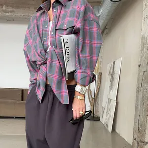 Dettaglio di una camicia a quadri rosa e grigi da donna con vestibilità retrò ampia