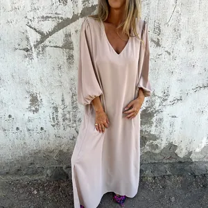 Detail showing the elegant V-neckline and loose lantern sleeves of this beige maxi dress.