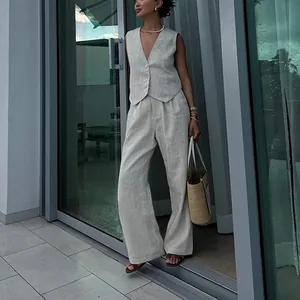 Vista completa del set chic in lino beige con gilet e pantaloni larghi sulla modella.