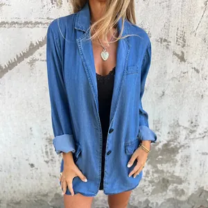 Detail view of a casual loose blue denim jacket for women with pockets and lapel.