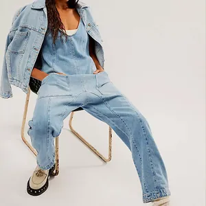 Detail shot of light wash denim jumpsuit with V-neck and pockets, styled with jacket.