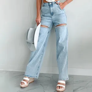 Detailed view of light blue distressed jeans featuring rhinestone-embellished thigh cut-outs.