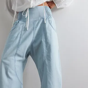 Detail shot of light blue washed denim harem pants with elastic drawstring waistband