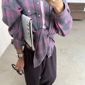 Dettaglio di camicia vintage a scacchi a maniche lunghe con tasca e nodo in vita