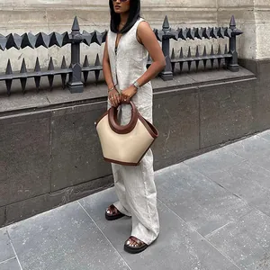 Foto street style di una donna con un set di gilet di lino beige e pantaloni larghi