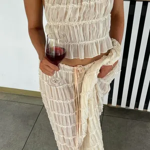 Détail d'un ensemble de vacances sexy avec haut dos nu à volants et jupe longue plissée