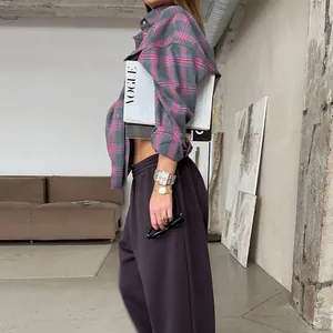Camicia a quadri alla moda abbinata a pantaloni sportivi e una rivista VOGUE di lusso