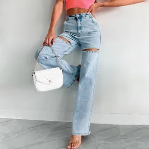 Detailed shot of women's straight denim jeans with rhinestone-embellished ripped cut-outs.
