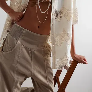 Close-up of washed khaki harem denim pants with elastic waist and pocket detail.