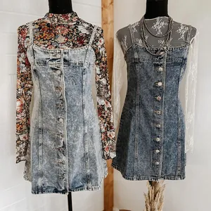 Detail van twee denim overgooier jurken in lichte en donkere wassing afwerkingen
