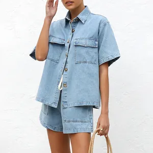Close-up detail of the loose light blue denim shirt and shorts two-piece set on a model