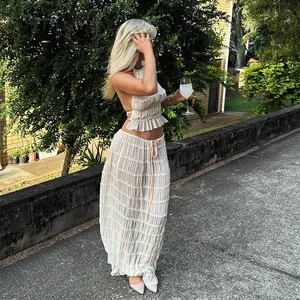 Élégant mannequin portant un ensemble haut blanc plissé dos nu et jupe longue d'été