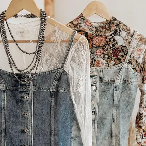 Detailopname van een versleten denim jurk met stijlvolle kant en bloemen gelaagdheid.
