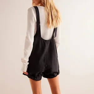 Back view of black washed denim overalls with adjustable straps and white knit top.