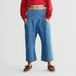 Full view of women's washed blue harem denim pants with dropped crotch and straight cropped leg