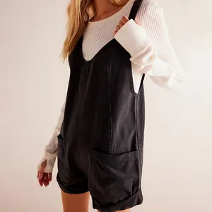 Detail of black washed denim romper with functional side pockets and adjustable straps