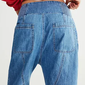 Close-up of back pockets on high-waisted washed blue harem denim jeans for women.