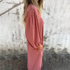 Side view detail of loose pink lantern sleeve dress with functional side pockets