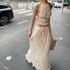 Détail d'un ensemble de vacances beige avec haut dos nu à volants et jupe longue