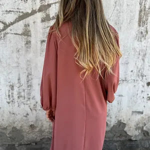 Back view of a casual solid color lantern sleeve dress with soft fabric texture