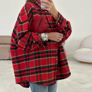 Dettaglio di una camicia a maniche lunghe a quadri rossi e neri oversize con tasche