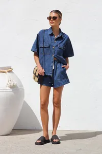 Model wearing a casual two-piece denim set with short-sleeved shirt and matching shorts