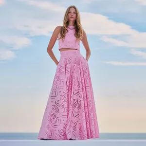 Model trägt ein zweiteiliges Resort-Set aus rosa ärmelloser Stickspitze mit langem Rock
