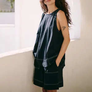 Close-up of black denim two-piece set featuring striking white contrast stitching.