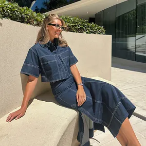 Lifestyle view of women's denim two-piece set with short sleeve shirt and slit skirt
