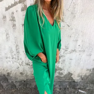 Detail of a casual loose green V-neck dress with elegant lantern sleeves and side pockets.