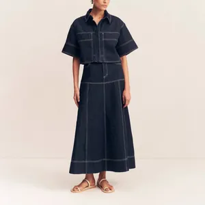 Detailed view of women's navy denim two-piece set with white contrast stitching