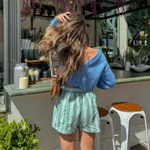 Detail view of green and white striped beach shorts with elastic waist for summer