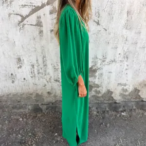 Detailed side view of loose green maxi dress featuring elegant lantern sleeves and side slits