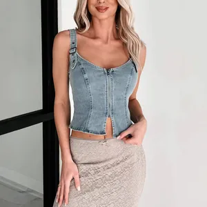 Close-up detail of light blue denim sleeveless vest with front zipper and buckle straps
