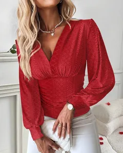 Detailansicht einer roten langärmeligen Bluse mit elegantem V-Ausschnitt und Taillenraffung