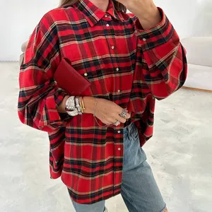 Dettaglio di una camicia a quadri rossa oversize con bottoni vintage e taschino sul petto.