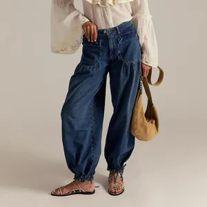 Detail view of women's loose balloon denim pants with adjustable drawstring hem in dark blue